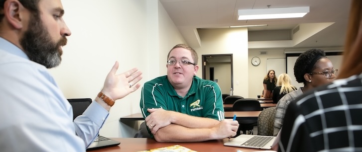 Students talking at desk during class